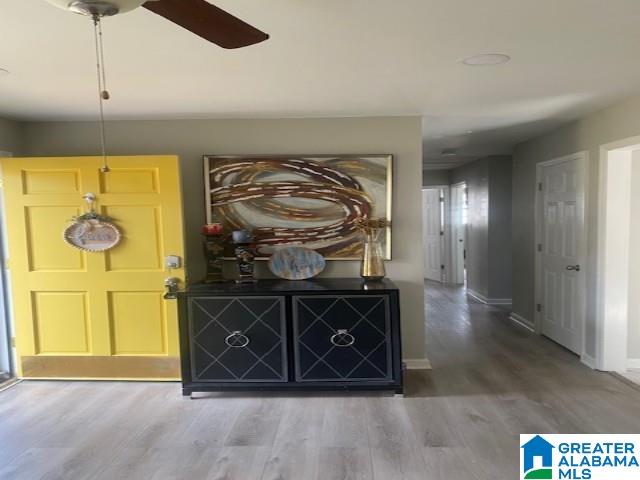 hallway with wood finished floors and baseboards