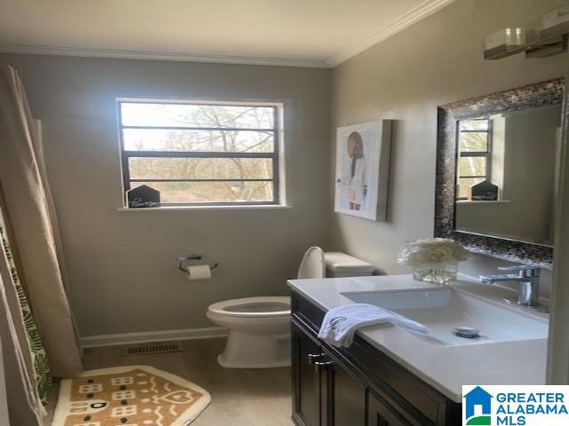 full bathroom featuring curtained shower, toilet, ornamental molding, vanity, and baseboards