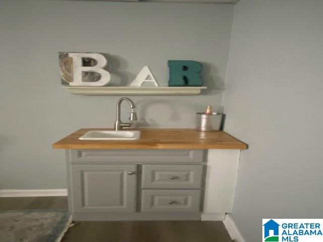 bar featuring a sink and baseboards