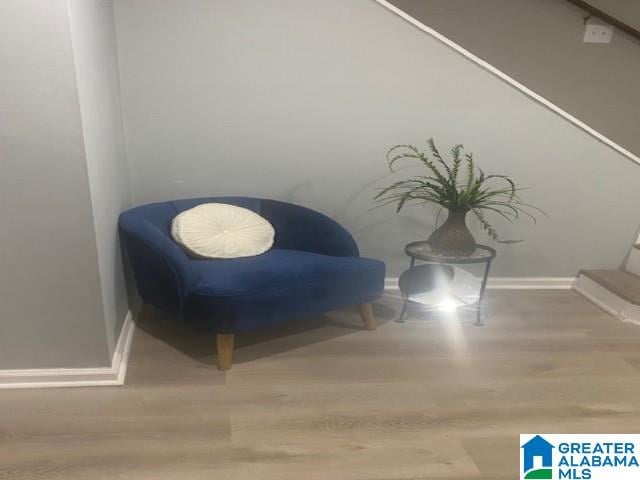 sitting room with baseboards and wood finished floors