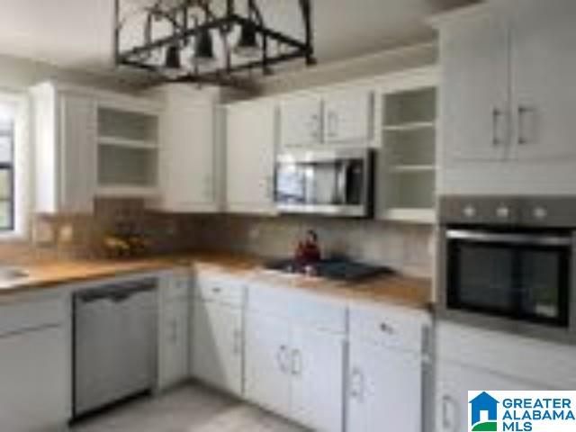 kitchen with white cabinetry, stainless steel appliances, and light countertops