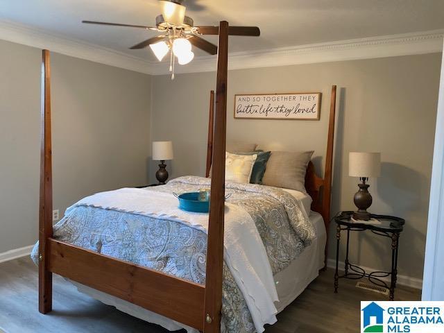 bedroom with ceiling fan, baseboards, wood finished floors, and crown molding