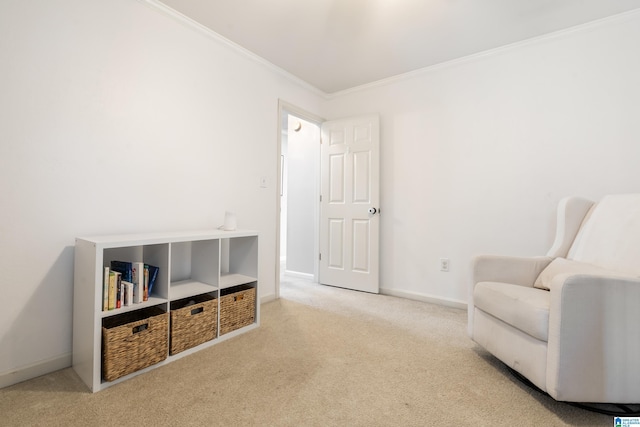 sitting room with ornamental molding and light colored carpet