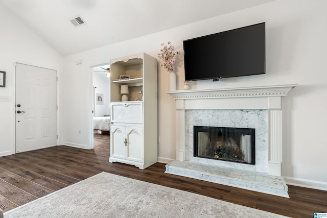 unfurnished living room with a high end fireplace, dark hardwood / wood-style flooring, and vaulted ceiling