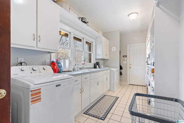 washroom featuring a sink, washer / dryer, cabinet space, and light tile patterned flooring