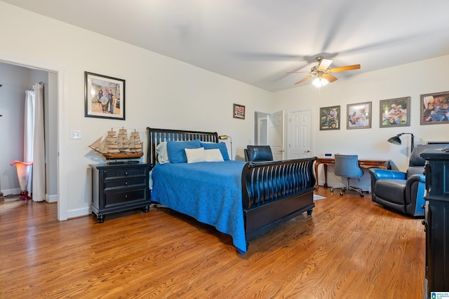 bedroom with ceiling fan, baseboards, and wood finished floors