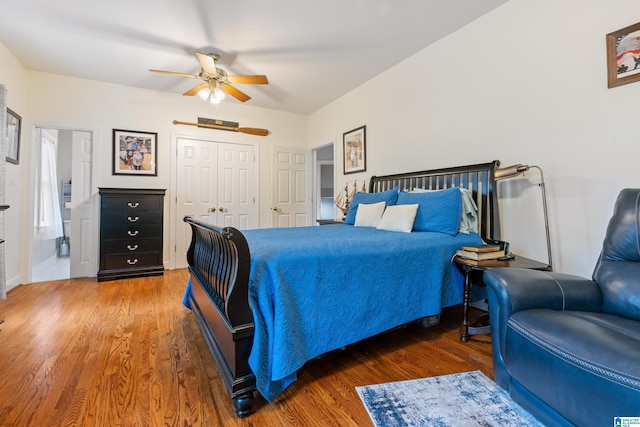 bedroom featuring ensuite bathroom, a closet, dark wood finished floors, and a ceiling fan