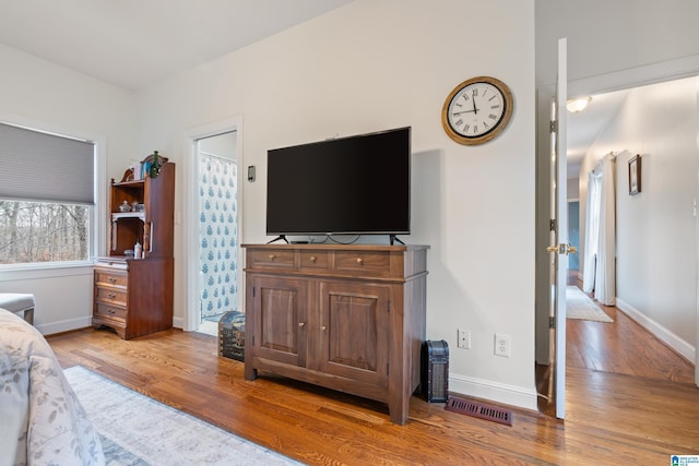 bedroom with baseboards, visible vents, and light wood-style floors