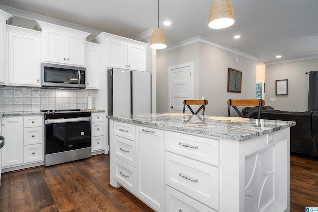 kitchen with stainless steel appliances, decorative light fixtures, a breakfast bar, and white cabinets