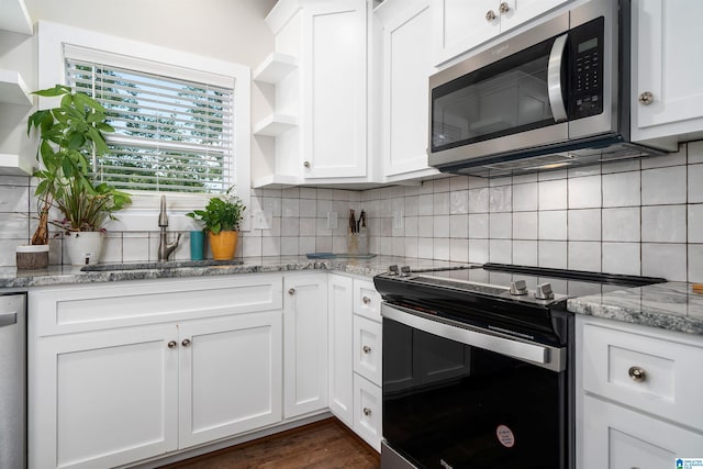 kitchen featuring sink, appliances with stainless steel finishes, light stone counters, tasteful backsplash, and white cabinets