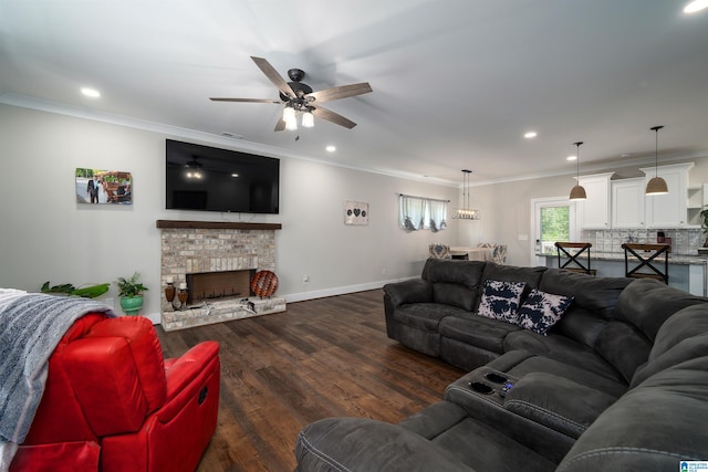 living room featuring ornamental molding, ceiling fan, a fireplace, and dark hardwood / wood-style flooring