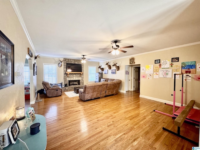 living room with crown molding, a stone fireplace, and light wood-type flooring