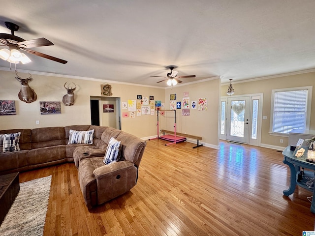 living room with ceiling fan, ornamental molding, and light hardwood / wood-style flooring