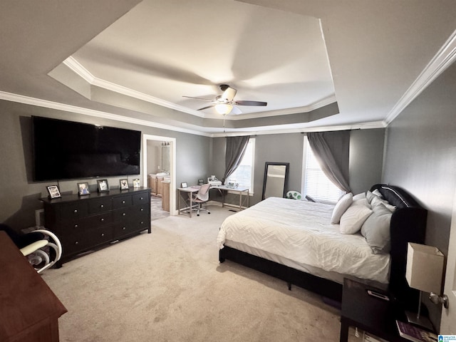 carpeted bedroom featuring crown molding, ceiling fan, ensuite bathroom, and a raised ceiling