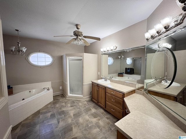 bathroom with vanity, ceiling fan with notable chandelier, shower with separate bathtub, and a textured ceiling