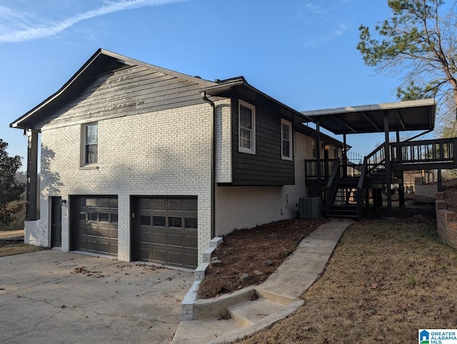 view of side of home with a garage, cooling unit, and a deck