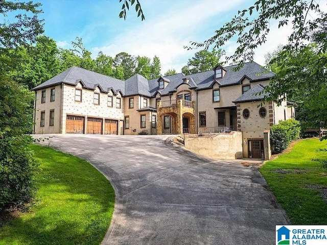 french country style house featuring concrete driveway, stone siding, and an attached garage