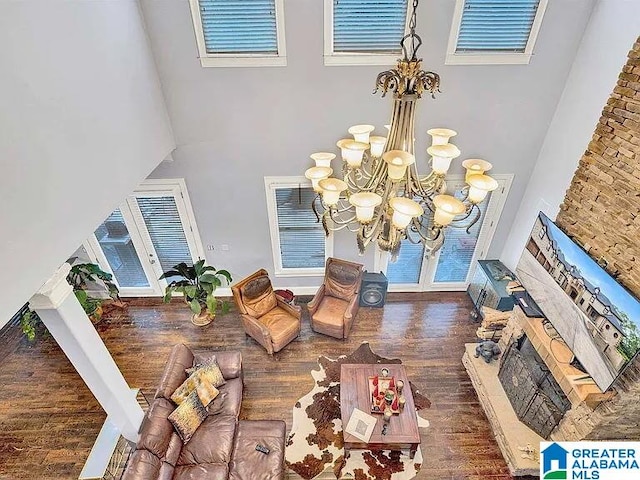 living room featuring a high ceiling, visible vents, dark wood finished floors, and a notable chandelier