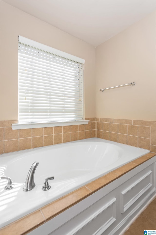 bathroom featuring tile patterned flooring, a healthy amount of sunlight, and a bathtub