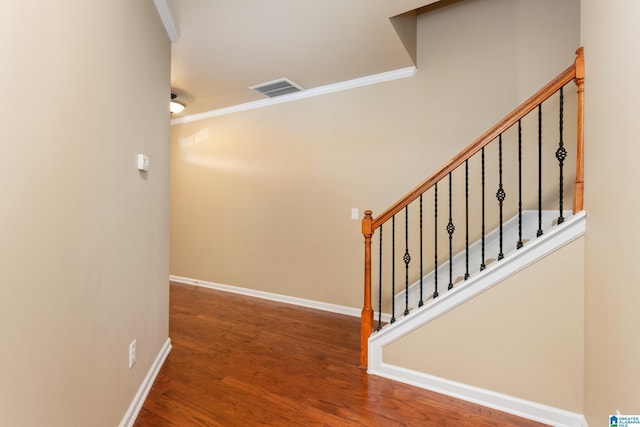 staircase featuring hardwood / wood-style flooring and crown molding