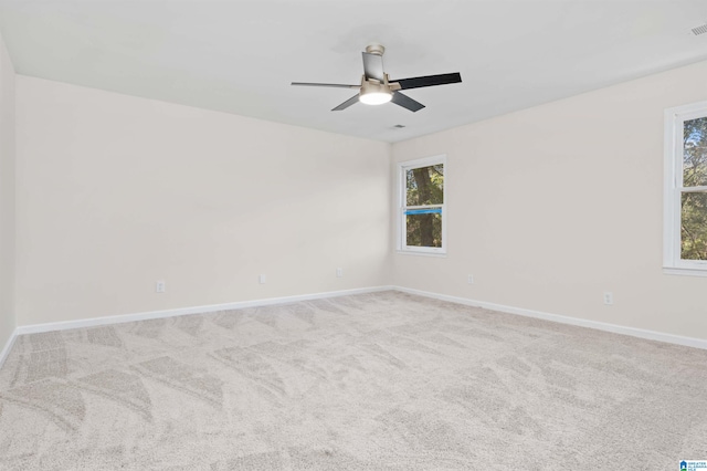 unfurnished room with light colored carpet and ceiling fan