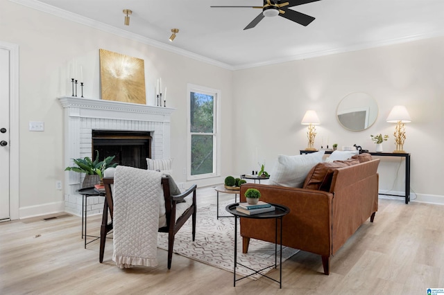 living room featuring crown molding, a fireplace, and light hardwood / wood-style floors