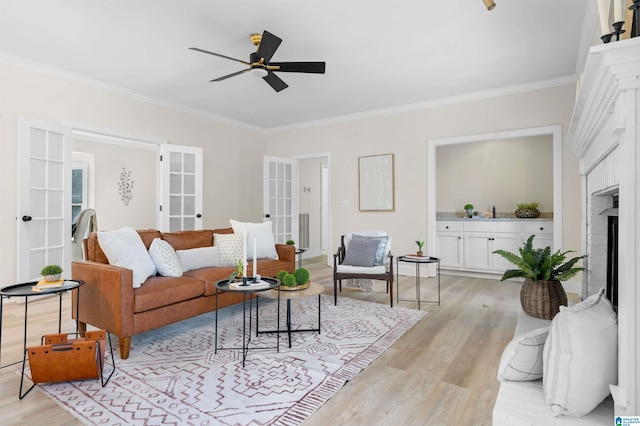 living room featuring a brick fireplace, french doors, ceiling fan, and light wood-type flooring