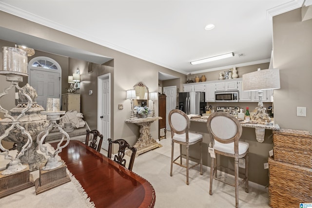 carpeted dining room featuring ornamental molding