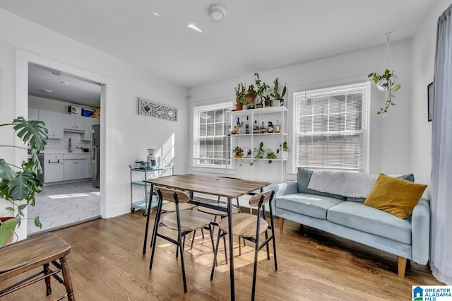 dining room featuring light wood-style flooring and baseboards