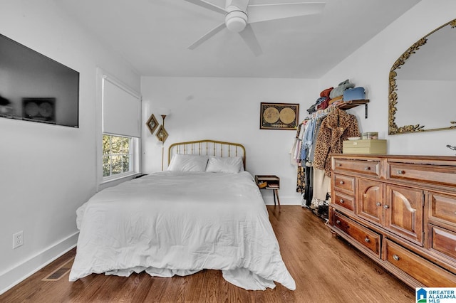 bedroom with baseboards, light wood finished floors, visible vents, and a ceiling fan