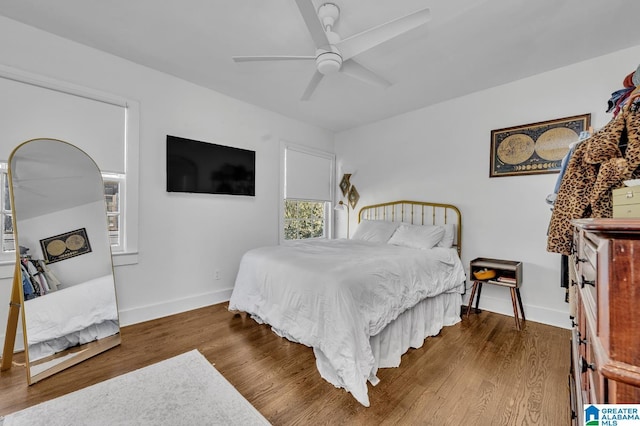 bedroom featuring dark wood-style floors, ceiling fan, and baseboards