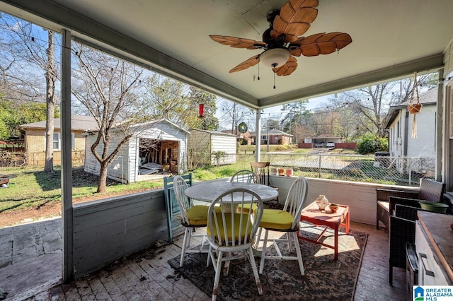 view of patio / terrace with outdoor dining area, ceiling fan, fence, a shed, and an outdoor structure