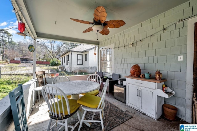 view of patio with outdoor dining area, fence, and a ceiling fan