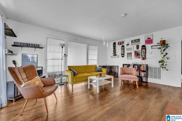 living area featuring visible vents and wood finished floors