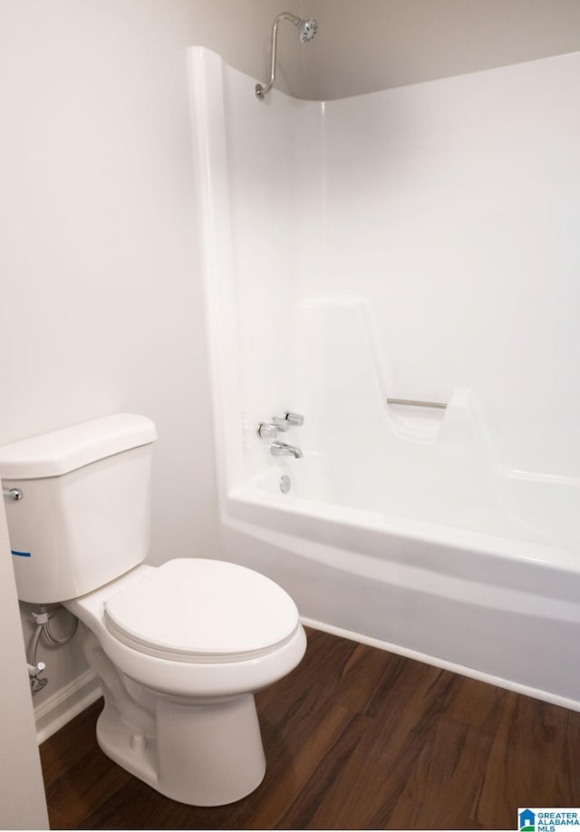 bathroom featuring shower / bathing tub combination, hardwood / wood-style flooring, and toilet