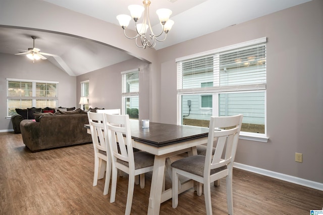 dining room featuring lofted ceiling, ceiling fan with notable chandelier, wood-type flooring, and a healthy amount of sunlight