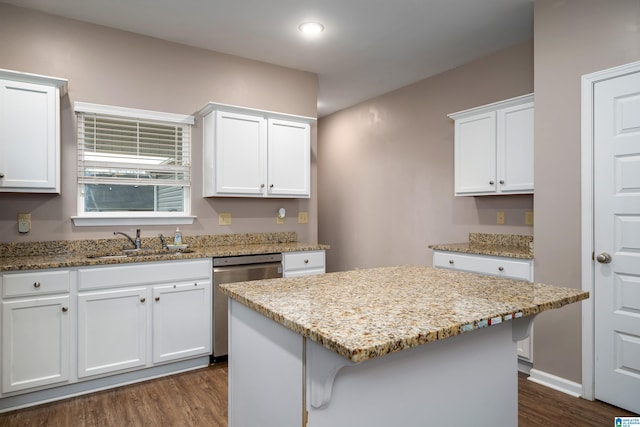kitchen featuring sink, white cabinetry, dishwasher, a kitchen island, and light stone countertops