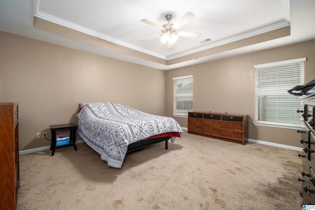 carpeted bedroom featuring crown molding, a tray ceiling, and ceiling fan