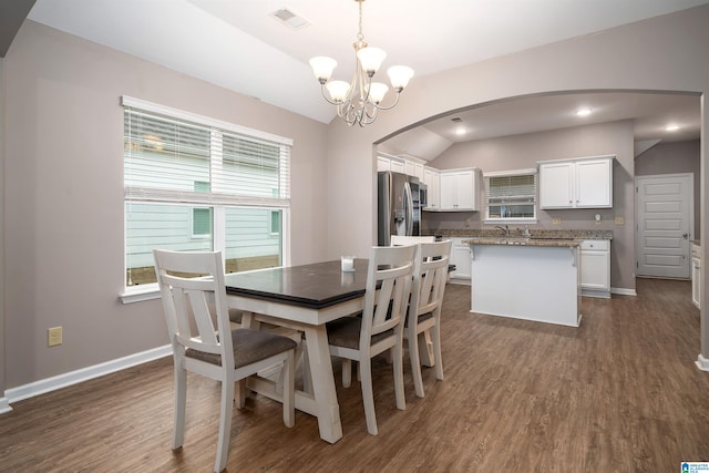 dining room featuring an inviting chandelier, dark wood-type flooring, and plenty of natural light