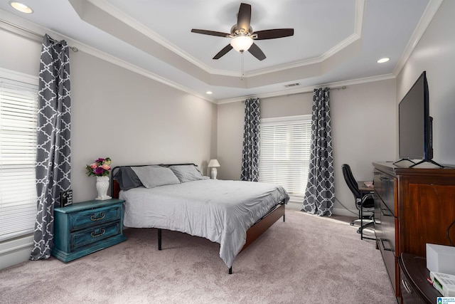 bedroom with a raised ceiling, ceiling fan, carpet floors, and ornamental molding