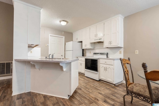 kitchen featuring a breakfast bar, white cabinetry, dark hardwood / wood-style floors, kitchen peninsula, and white appliances