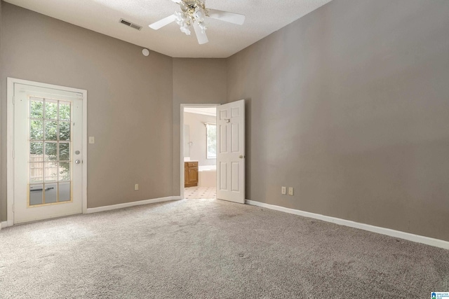 carpeted spare room with a textured ceiling and ceiling fan