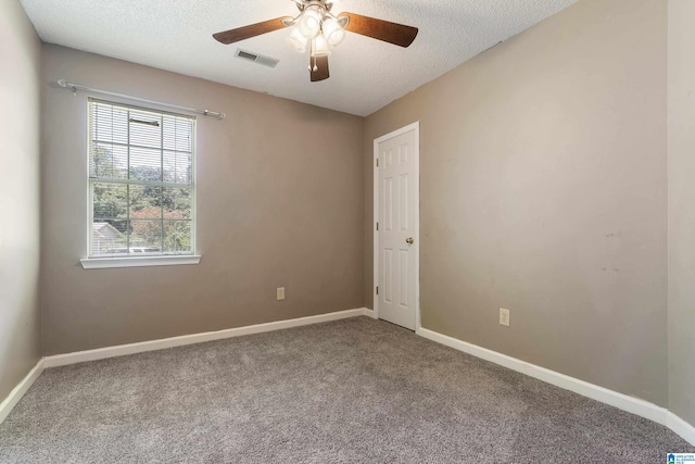 carpeted empty room featuring ceiling fan and a textured ceiling