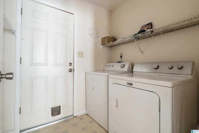 clothes washing area with washer and clothes dryer