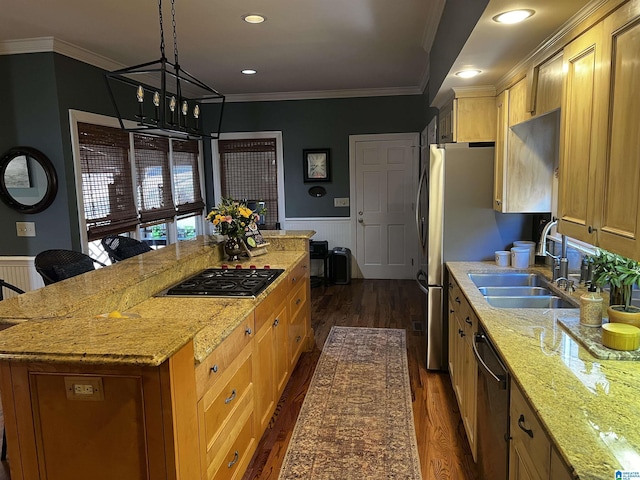 kitchen featuring appliances with stainless steel finishes, wainscoting, a sink, and a center island