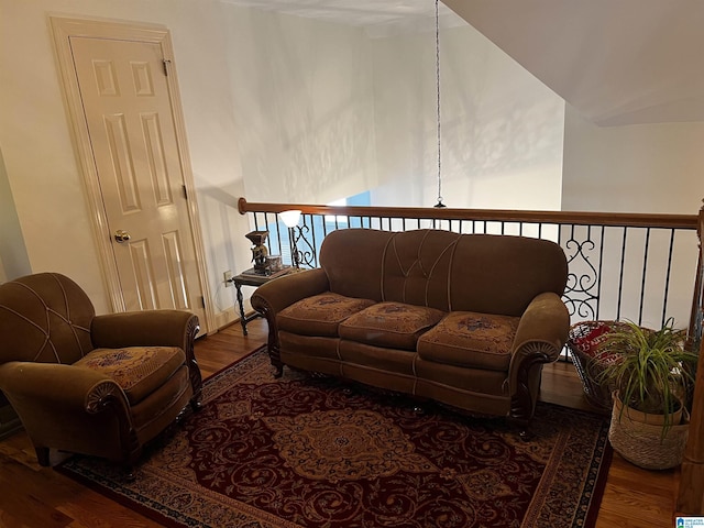 living area featuring vaulted ceiling and wood finished floors