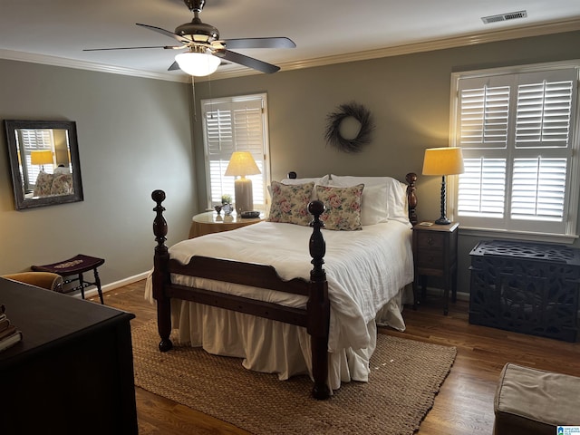 bedroom with ornamental molding, wood finished floors, visible vents, and baseboards