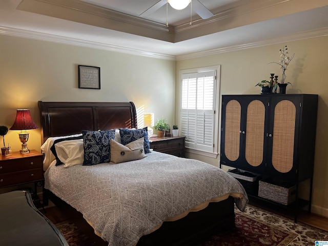 bedroom with a ceiling fan, a tray ceiling, and crown molding