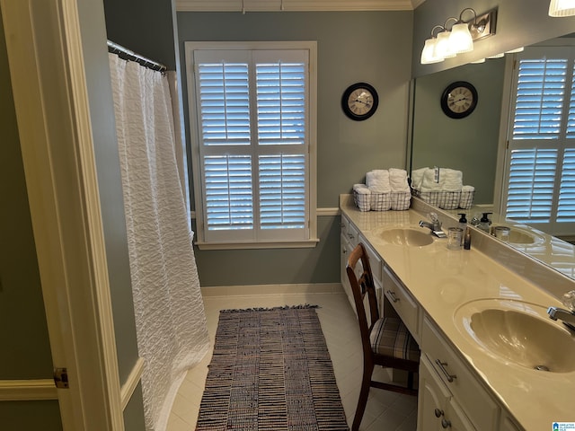 bathroom featuring crown molding, tile patterned floors, a sink, and double vanity