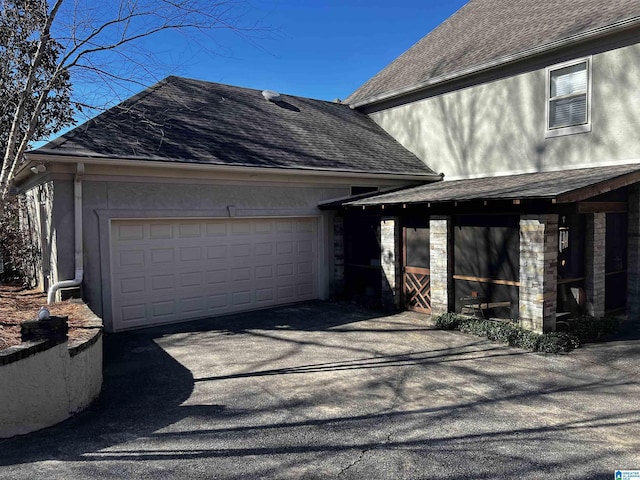 view of property exterior with a garage, stone siding, roof with shingles, and aphalt driveway